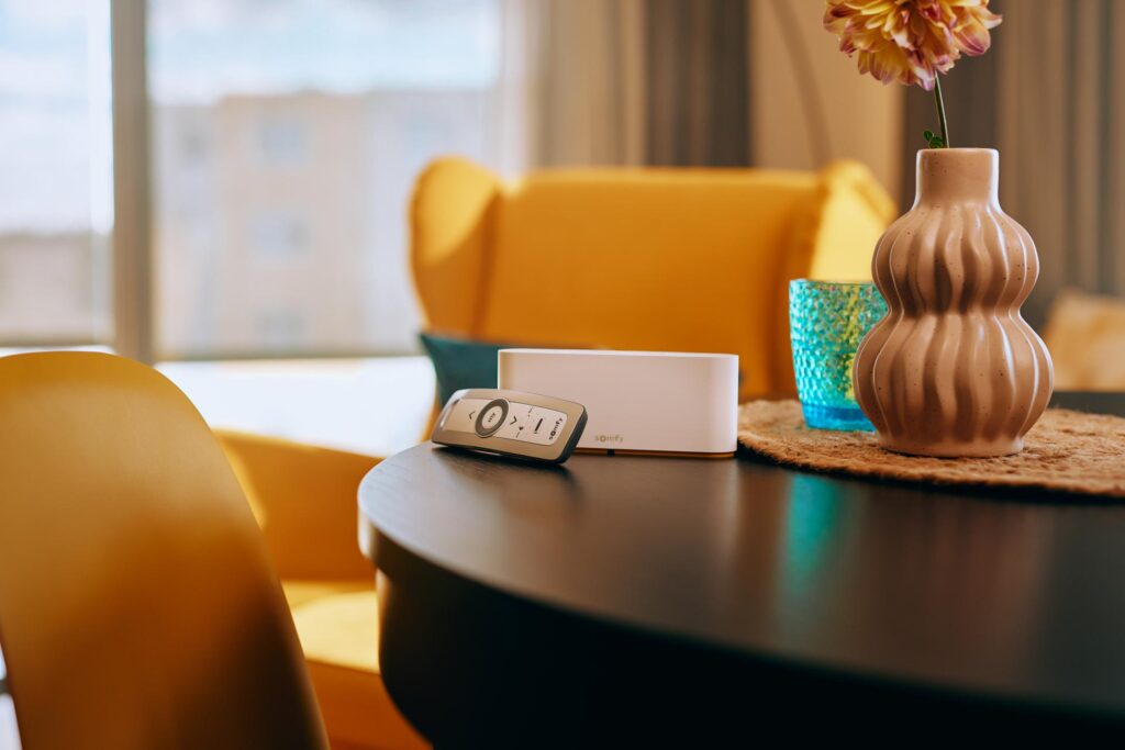 Screenové rolety v obývacím pokoji se žlutým křeslem